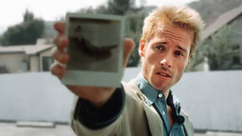 Guy Pearce as Leonard Shelby holding a Polaroid photograph in Memento (2000)