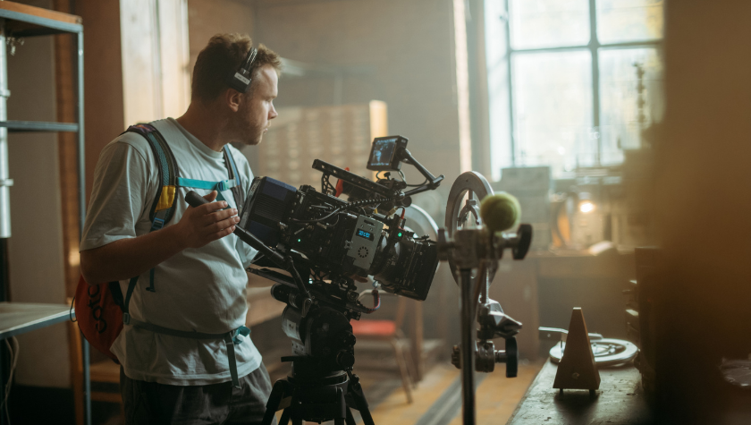 A camera operator lines up a shot on an interior film set