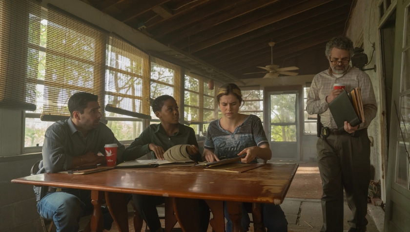 Four FBI team members gathered around a table reviewing case files in a scene from Task on HBO