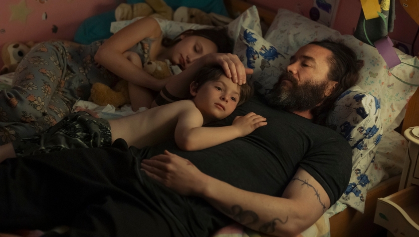 Robbie Pendergrass (Tom Pelphrey) lies in bed with his two children in a tender scene from Task on HBO
