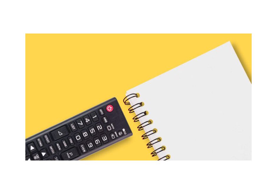 Empty notebook next to a television remote