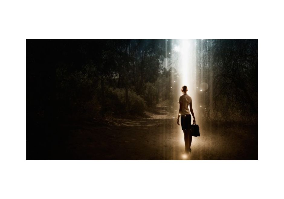 Person outdoors lit by a narrow shaft of light