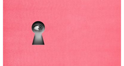 Close-up of a human eye looking through a keyhole on a pink background