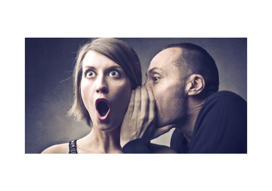 Man whispering in surprised woman's ear