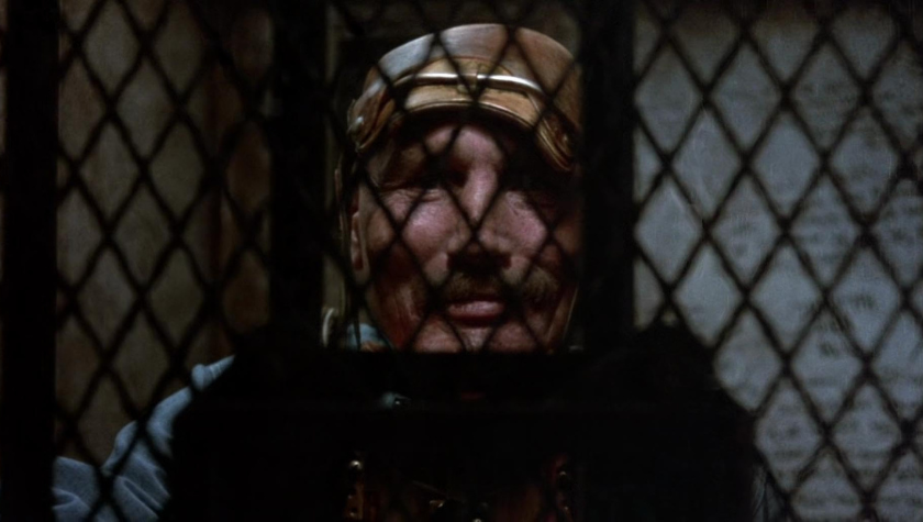 Edward Bunker staring through a tightly woven barrier in 'Runaway Train'
