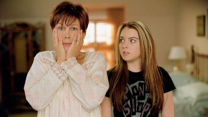 Jamie Lee Curtis stands with her hands on her face as Lindsay Lohan stares at her in Freaky Friday