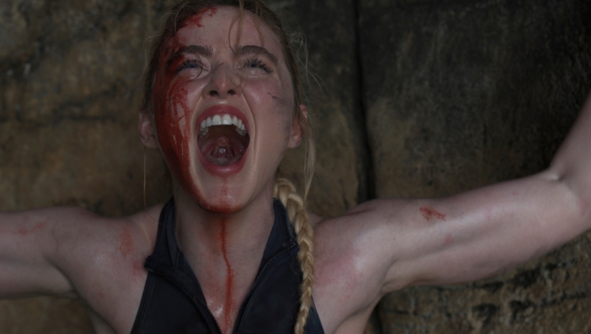 "A blood-covered survivor screams in the cave after a shark attack in a scene from The Devil's Mouth