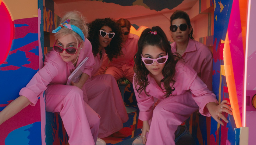 Michael Cera, America Ferrera, Margot Robbie, Alexandra Shipp, and Ariana Greenblatt wear pink jumpsuits and sunglasses as they hold the back doors to a van open in 'Barbie'