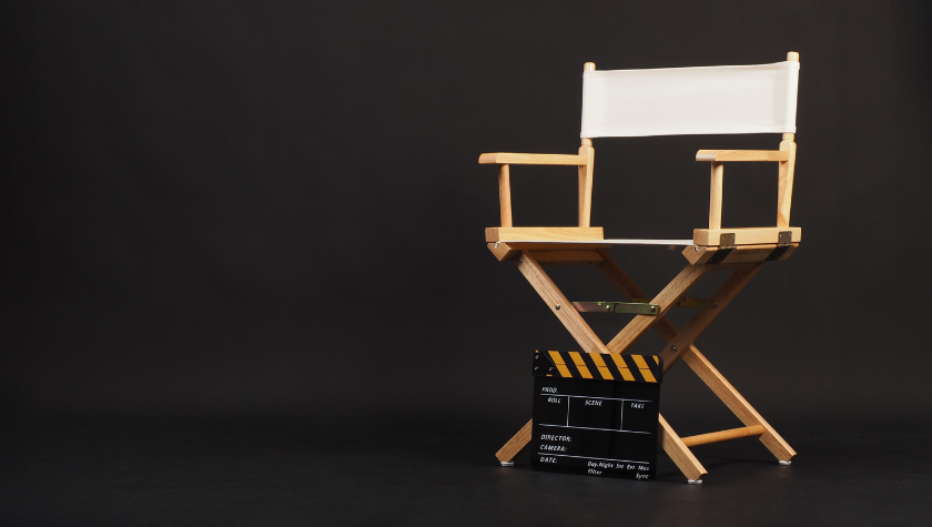 White director chair with a clapper board sitting in front of it
