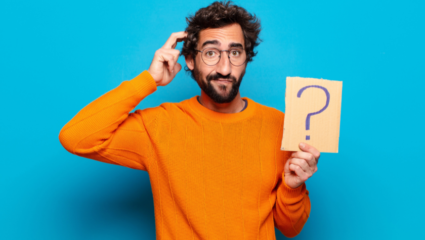 confused man with glasses holding a question mark sign