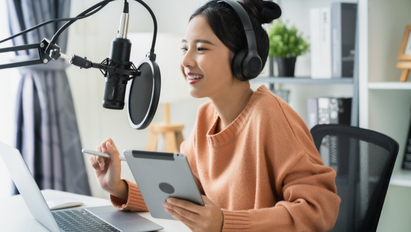 female content creator sitting at desk with devices